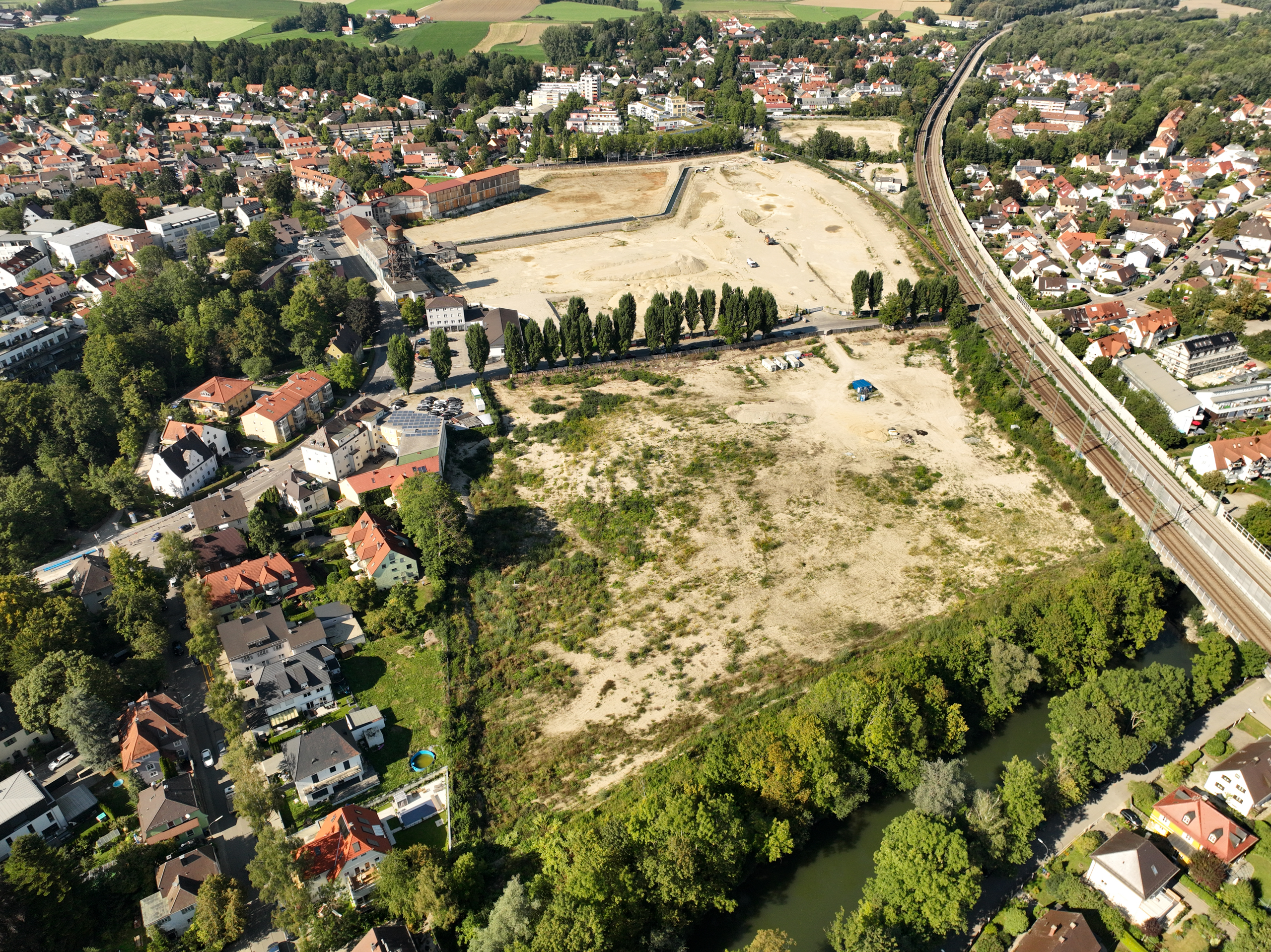 Drone image of the Papierfabrik Dachau: the still undeveloped landscape on which the project is to be built can be seen.