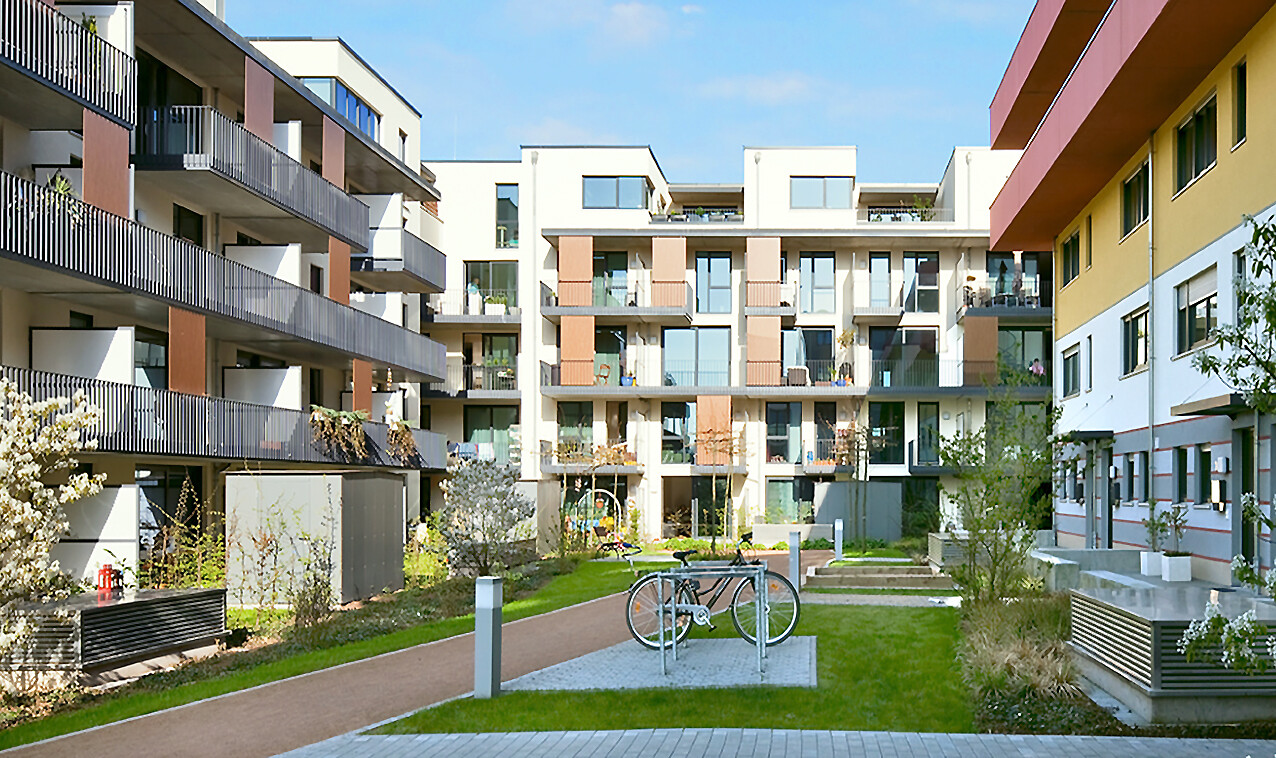 With a view from the courtyard to the front view and a parking space for bikes of the BUWOG new building project coloneo in the Rhein-Main area