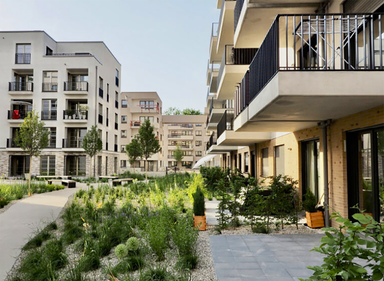 You can see the quarter's residential buildings with balconies, green spaces and trees.