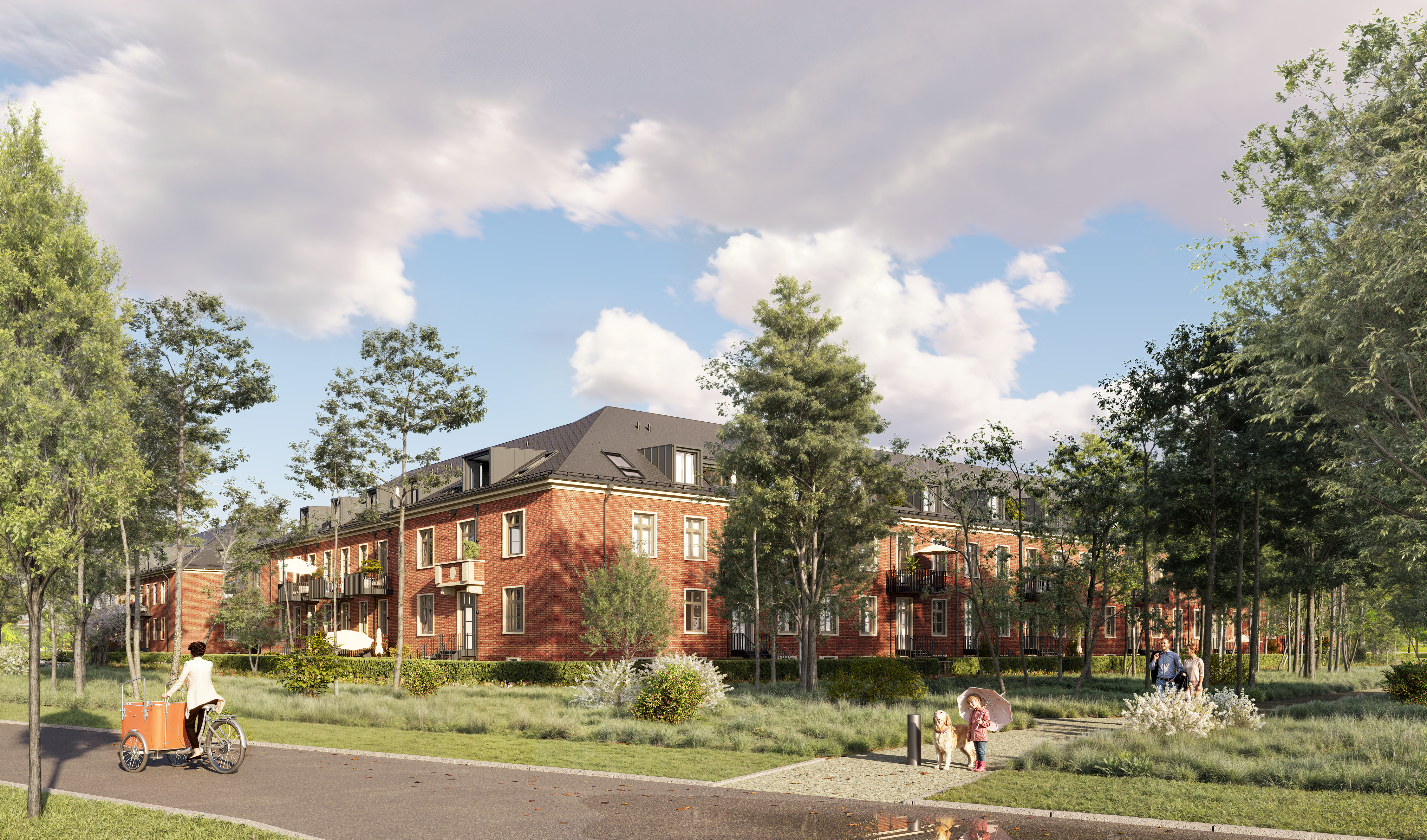 Several brown houses of the BUWOG Lillestad project can be seen from the street. You can also see a pavement from the project to the street with people on it. There is a cyclist on the road.