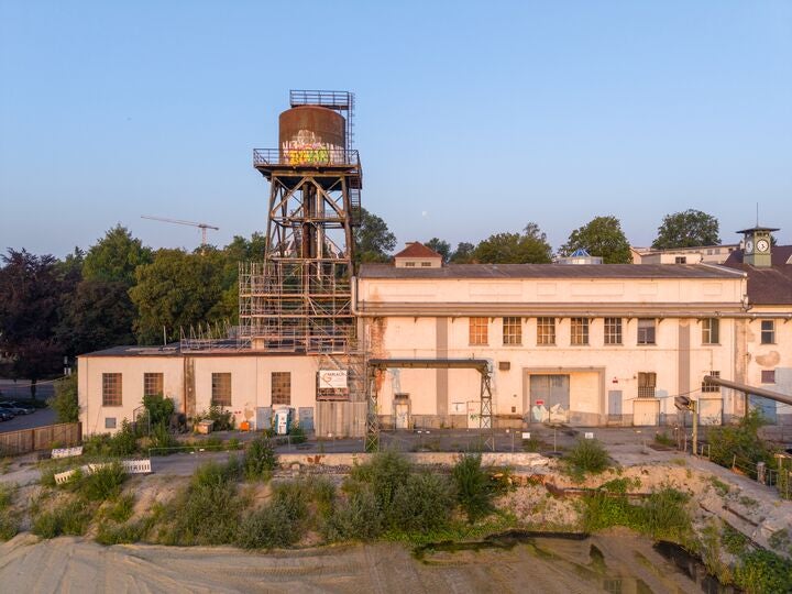 Historischer Förderturm und angrenzendes Industriegebäude auf einem ehemaligen Zechengelände.