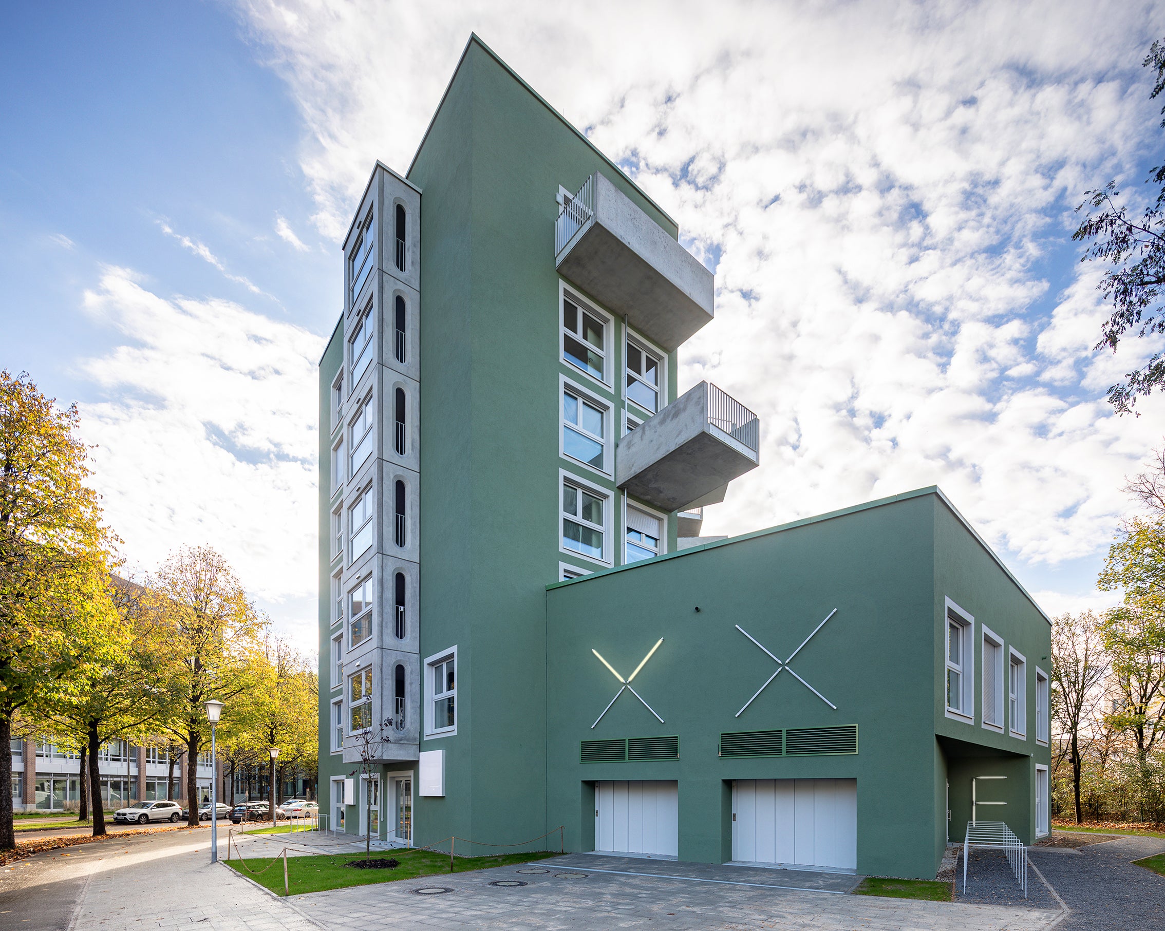 Zu sehen ist das Quartier ENJOY mit Blick von der Straße auf das Grüne Hochhaus.